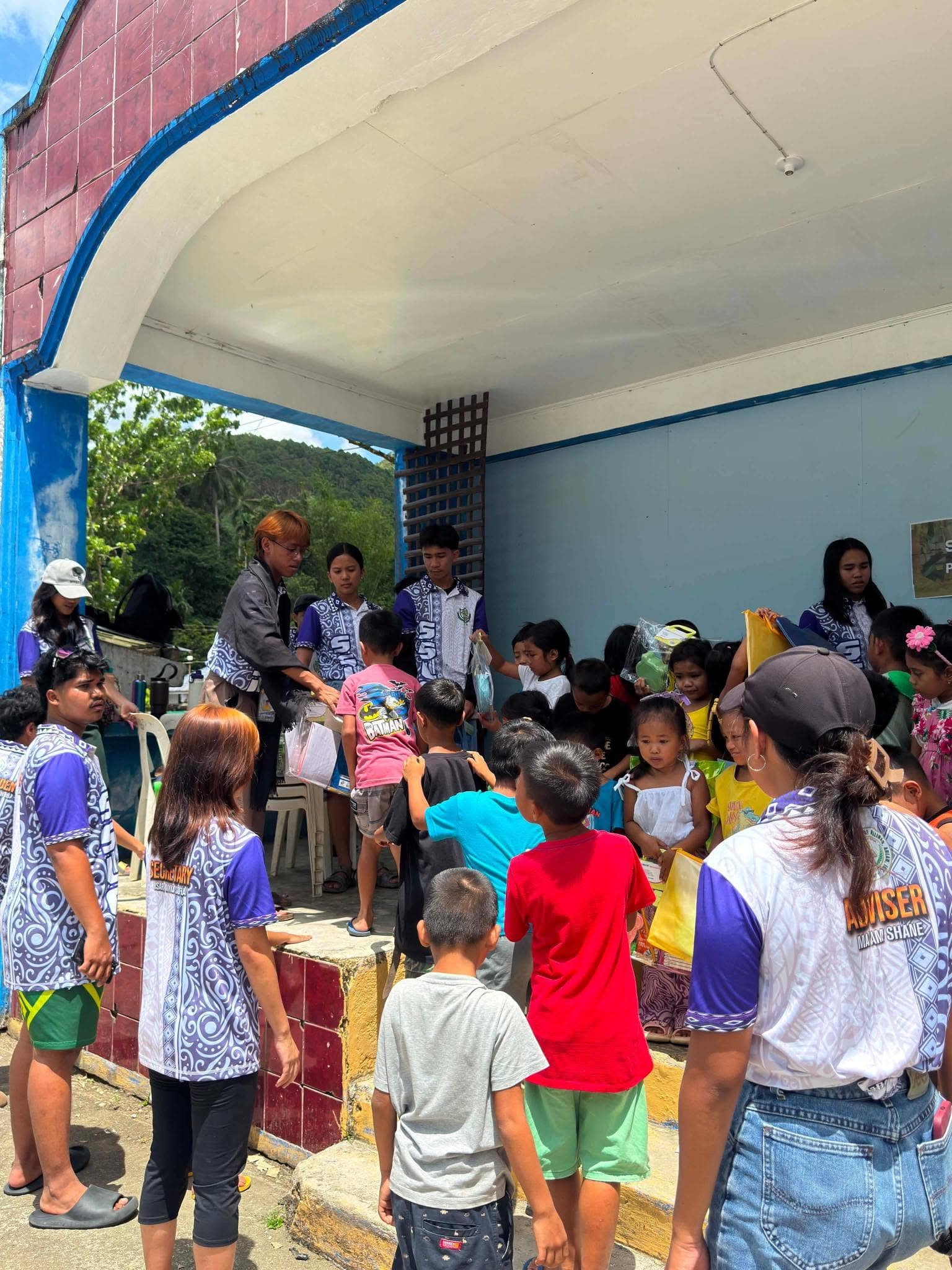 St. Joseph's Academy Guardians distributing school supplies to children during a community outreach visit