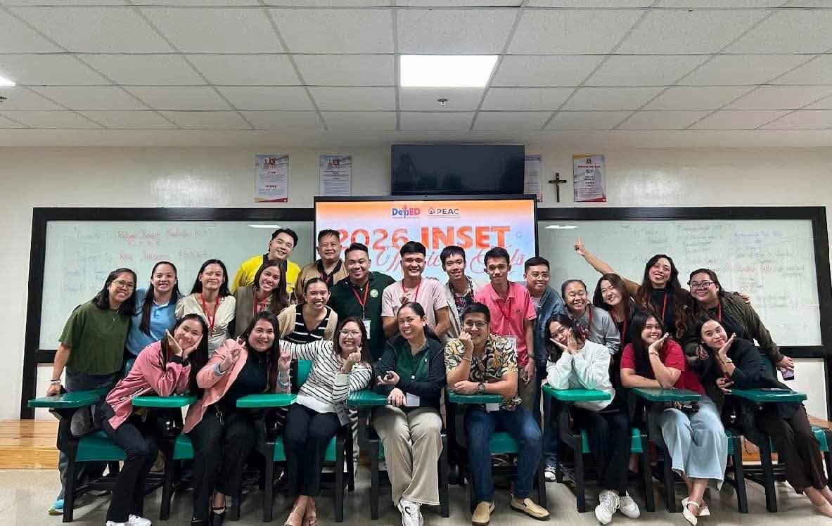 Training participants gathered for a group photograph in a classroom, in front of a screen reading 2026 INSET