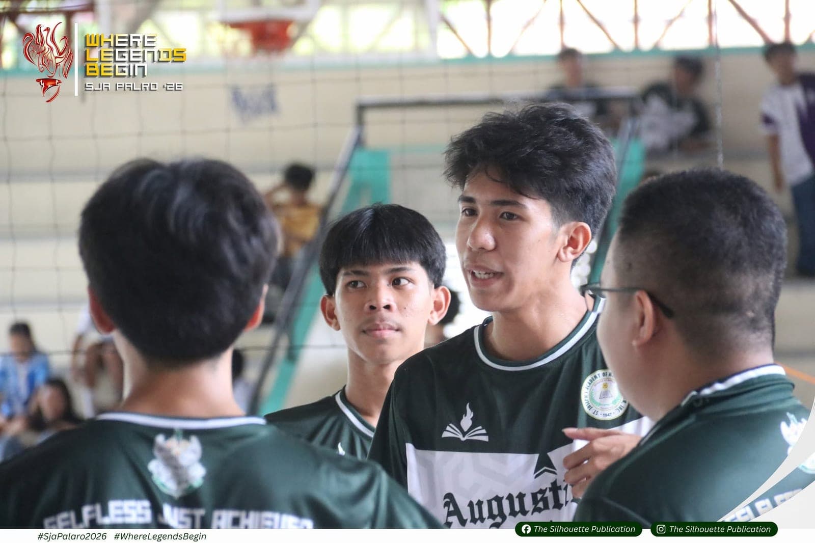 Augustinians players huddled at the net during a volleyball match